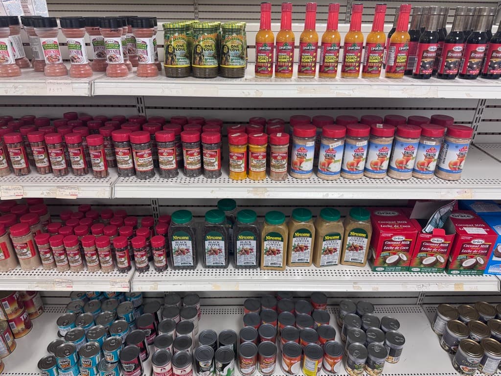 Caribbean scotch bonnet pepper sauces, spices and coconut milk on the shelf
